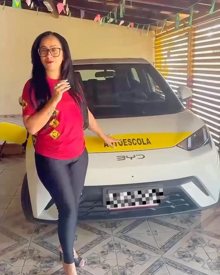 Tia Tati com o carro elétrico da autoescola